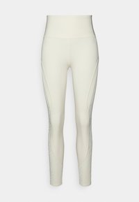 Leggings de cintura alta en color crema con construcción sin costuras, que cuentan con paneles laterales texturizados y un acabado suave en la parte delantera y trasera.