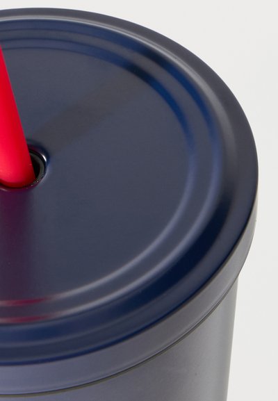 Σκούρο μπλε κύπελλο με καπάκι και κόκκινο επαναχρησιμοποιούμενο καλαμάκι που εισάγεται μέσα από την κεντρική οπή του καπακιού.