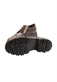 Scarpa oxford in pelle marrone con punta arrotondata, design wingtip, dettagli perforati e suola in gomma spessa con profonde scanalature.