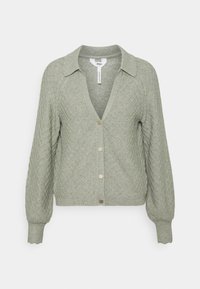 Lys grøn strikket cardigan med et diamantmønster, knaplukning, krave og ribbede manchetter. Blød tekstur og let cropped design.