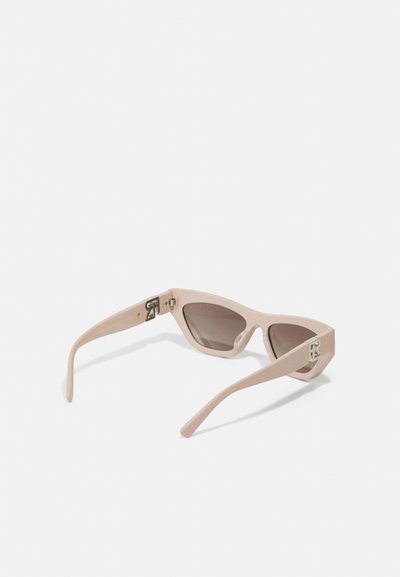 A pair of sunglasses with a light beige plastic frame, angular design, tinted lenses, and silver hardware accents on the temples.