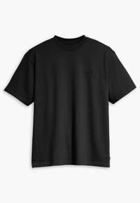 T-shirt en coton noir avec des manches courtes, un col rond et un logo subtil embossé sur la poitrine. Texture lisse, coupe décontractée.