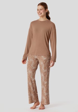 Camicia a maniche lunghe marrone leggera abbinata a pantaloni a fantasia con disegni di foglie in beige, che offrono una vestibilità comoda e una texture liscia.
