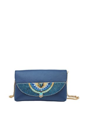 Pochette bleu marine avec bandoulière chaîne dorée, présentant un motif ailé brodé en sarcelle et or sur le rabat avant.