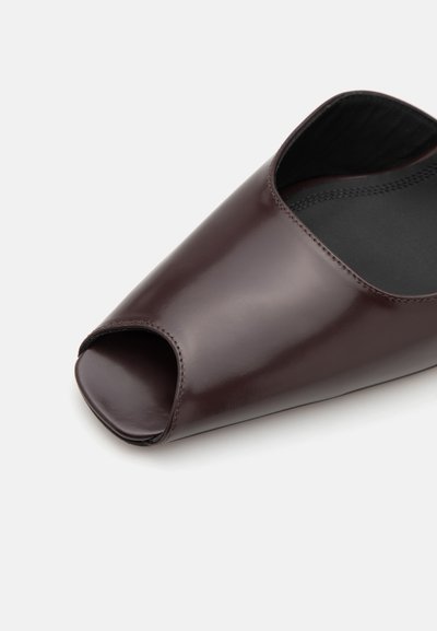 Bordeaux åbent tå lædersandal med en glat finish, let afrundet form og sort interiør. Har minimale syninger.