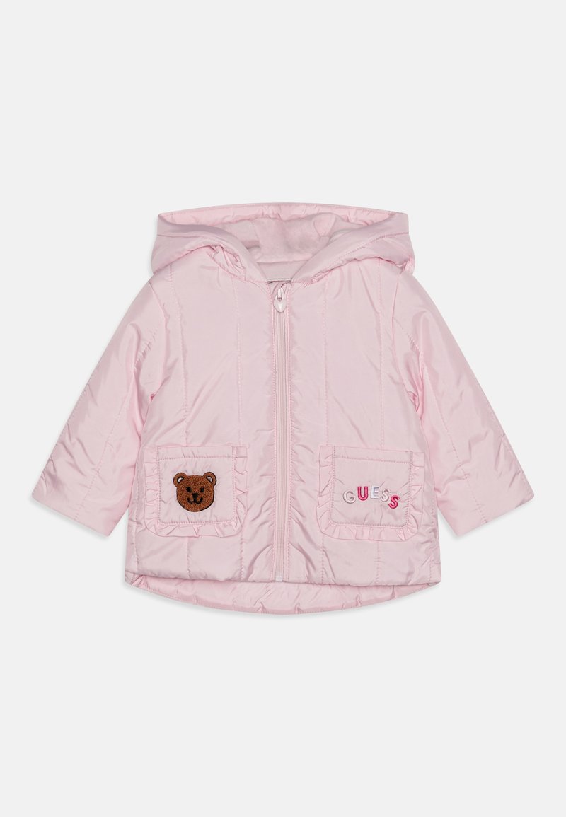 Pink quilted jacket with a hood, featuring a bear appliqué on one pocket and "GUESS" embroidered on the other. Soft fabric with zip closure.
