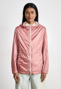 Chaqueta de color rosa claro con cierre delantero, cintura elástica, capucha ajustable y tejido brillante y suave. Presenta bolsillos laterales ocultos.