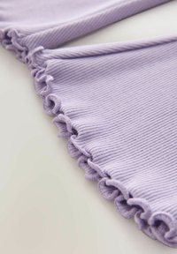Fialová rebrovaná textília s volánmi na okrajoch, s jemnou textúrou a zakriveným tvarom. Textília má konzistentný vzor po celej ploche.