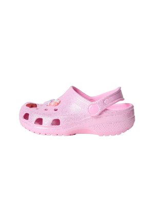 Sabot en caoutchouc rose pour enfant avec des trous de ventilation et des breloques décoratives sur le dessus, avec une bride au talon pour un maintien sûr.