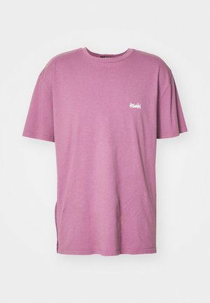 Violetti oversized T-paita lyhyillä hihoilla ja pienellä valkoisella "tsubi" tekstilogolla vasemmassa rinnassa, esitetty yksinkertaisen valkoisen taustan edessä.