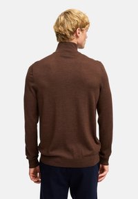 Maglione marrone a maglia con colletto alto, maniche lunghe e orlo a coste. Texture morbida con cuciture uniformi. Nessun motivo o accento visibile.
