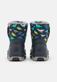 Botas negras y azul marino con un patrón de dinosaurios en verde, gris y blanco. Cuentan con un interior suave en gris y una suela negra duradera.