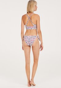 Bikini-Set mit einem mehrfarbigen, geometrischen Muster. Das Oberteil verfügt über ein Überkreuz-Trägerdesign, während die Bikinihose verstellbare Seitenbänder hat.