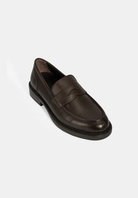 Braune Lederloafer mit strukturierter Oberfläche, runder Zehenform und einem rechteckigen Riemen über dem Vorderfuß. Niedrigprofil-Gummisohle.