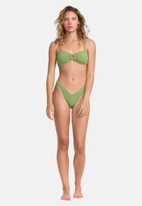 Completo bikini verde composto da un top bandeau con dettaglio anello centrale e spalline regolabili, abbinato a slip alte. Texture liscia.