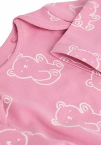 Rosa Baumwollschlafanzug mit weißen Bärenmustern. Mit kurzen Ärmeln und rundem Ausschnitt. Weiche, glatte Textur.