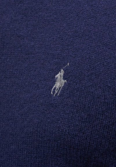 Suéter de malha azul-marinho com uma superfície texturizada e um pequeno logotipo de cavalo em relevo cinza-claro no lado esquerdo.
