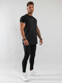 Svart kortärmad T-shirt med en figursydd design, mönstrade ärmdekorationer, kombinerad med svarta leggings och vita sneakers.
