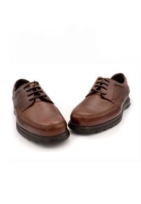 Zapatos de cuero marrón con una superficie lisa, punta redonda y diseño de cordones con seis ojetes. Presentan una suela de goma oscura y detalles cosidos.