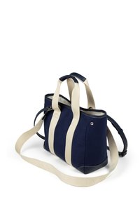 Marinblå canvasväska med krämfärgade randiga tygremmar, läderdetaljer och avtagbar axelrem. Har en dragkedjestängning och metalldetaljer.