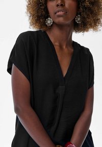 Czarny top z dekoltem w serek i krótkimi rękawami, wykonany z miękkiego, teksturowanego materiału o luźnym kroju, z gładkim akcentem w okolicy dekoltu.