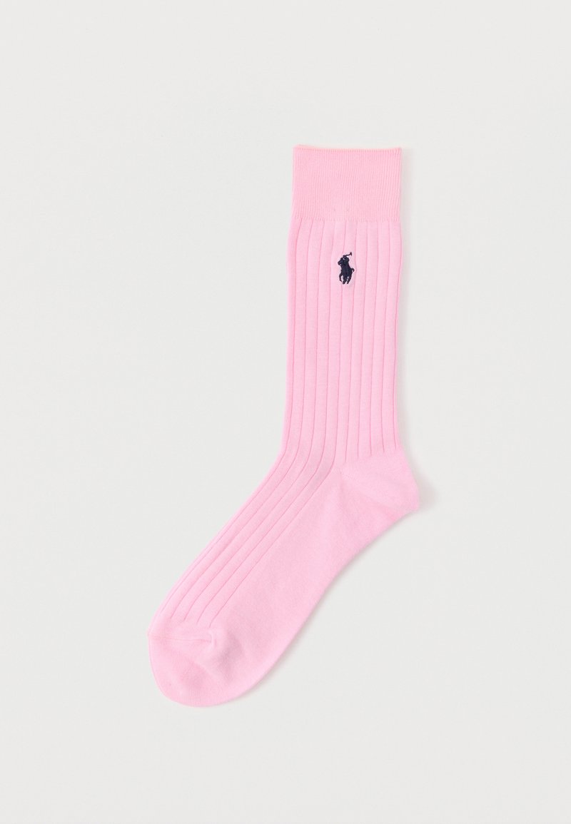 Ein einzelner rosa gerippter Socken mit schwarzem, gesticktem Polo-Spieler-Logo an der Wade vor einem schlichten hellen Hintergrund.