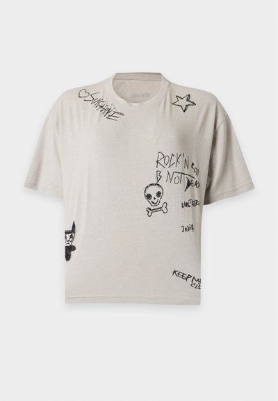 Μπεζ κοντομάνικη μπλούζα με μαύρα σκίτσα, συμπεριλαμβανομένου ενός κρανίου με σταυρωμένα κόκαλα, αστέρι, πρόσωπο γάτας και χειρόγραφες λέξεις όπως "Rock'n Roll is Not Dead."