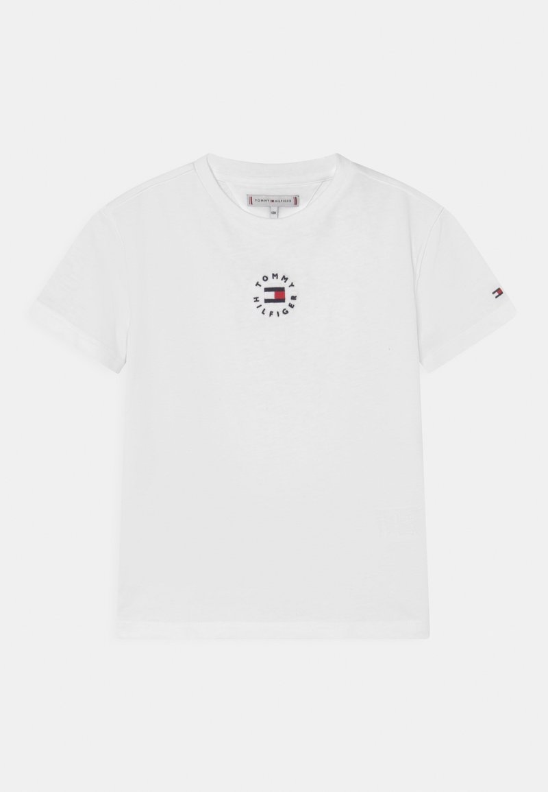 T-shirt bianco in cotone con un logo ricamato circolare in blu e rosso con la scritta "TOMMY HILFIGER". Design a maniche corte e girocollo.