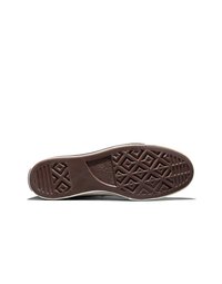 Semelle en caoutchouc brun d'une chaussure Converse All Star montrant des motifs texturés et le logo de la marque sur un fond blanc.