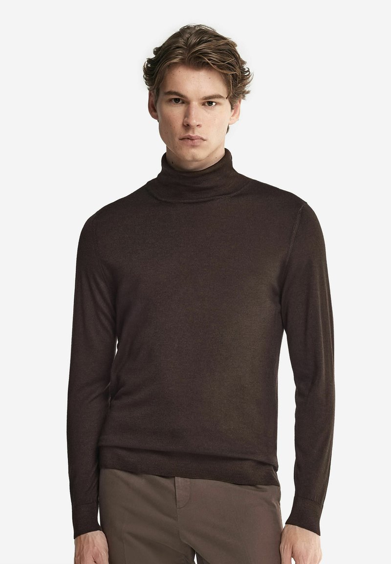 Mörkbrun polotröja i mjukt material, med lång ärm och en figurnära siluett. Slät textur och subtila designdetaljer.