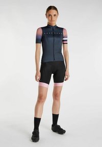 Maillot de cyclisme ajusté en bleu foncé avec des manches dégradées rose et une fermeture éclair, associé à un short noir avec des bandes roses à l' ourlet.