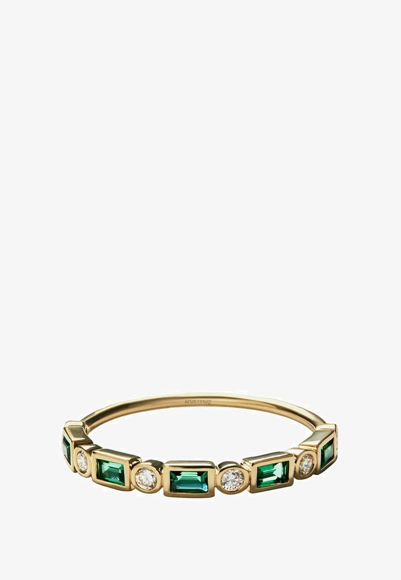 Anillo de banda de oro con gemas verdes rectangulares alternas y piedras claras redondas, con un acabado liso y textura pulida.