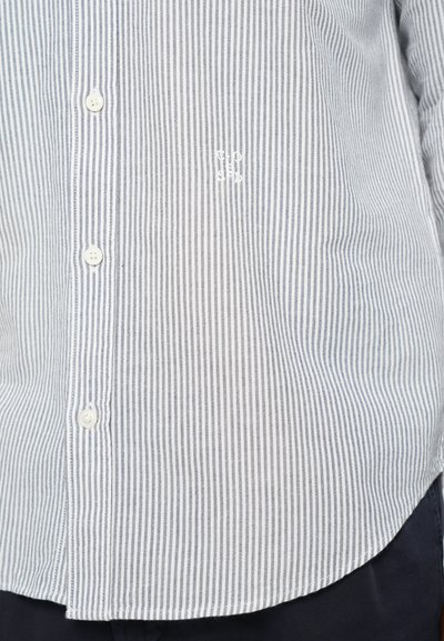 Camicia a righe blu e bianche con bottoni, realizzata in un tessuto morbido, colletto classico e piccolo logo ricamato vicino ai bottoni.