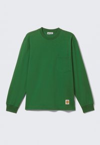 Green long-sleeve shirt in cotton jersey with a round neckline, chest pocket, and a logo patch at the bottom left. Smooth texture.