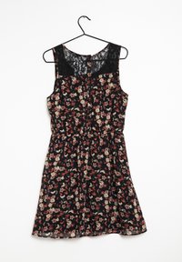 Robe fleurie avec une base noire, ornée de fleurs rouges et crème. Détails en dentelle aux épaules et au dos, taille élastique, et jupe évasée.