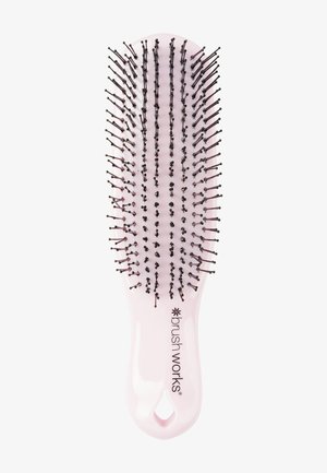Pink plastic hairbrush with black-tipped bristles, oval shape, and a hanging hole in the handle, branded "brush works."