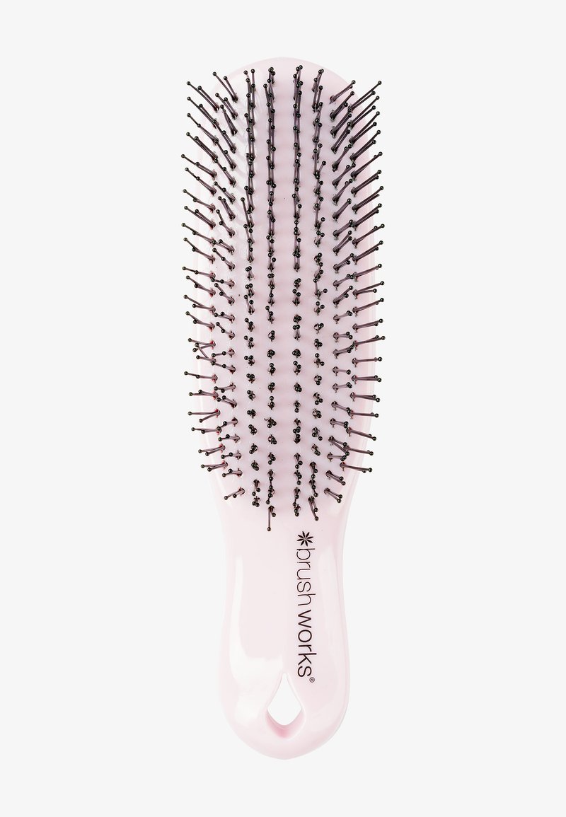 Pink plastic hairbrush with black-tipped bristles, oval shape, and a hanging hole in the handle, branded "brush works."