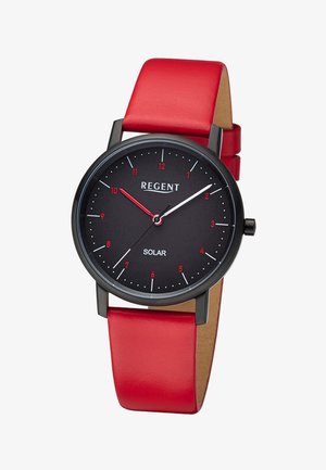 Montre solaire ronde noire avec chiffres rouges, aiguilles blanches et rouges, et un bracelet en cuir rouge vif.