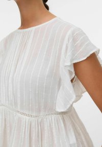 Wit katoenen jurk met korte gerafelde mouwen, verticale strepen en gestructureerde stippen. Heeft een geraffineerde taille en kanten accenten.