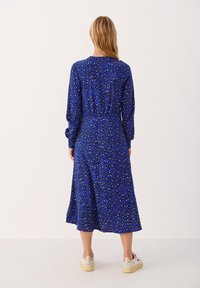 Långtärmad blå klänning med djurtryck, med en A-linjeformad silhuett och en avslappnad passform, tillverkad i lätt tyg.