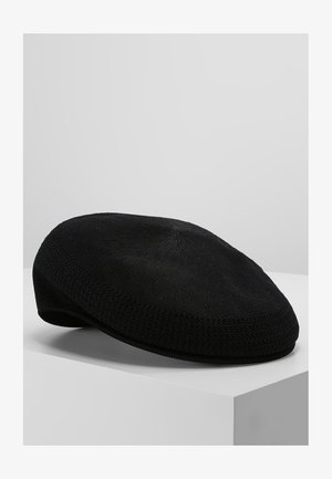 Berretto a maglia nero con forma arrotondata, caratterizzato da un motivo testurizzato e da un materiale morbido e flessibile. Accentuato da una fascia liscia.