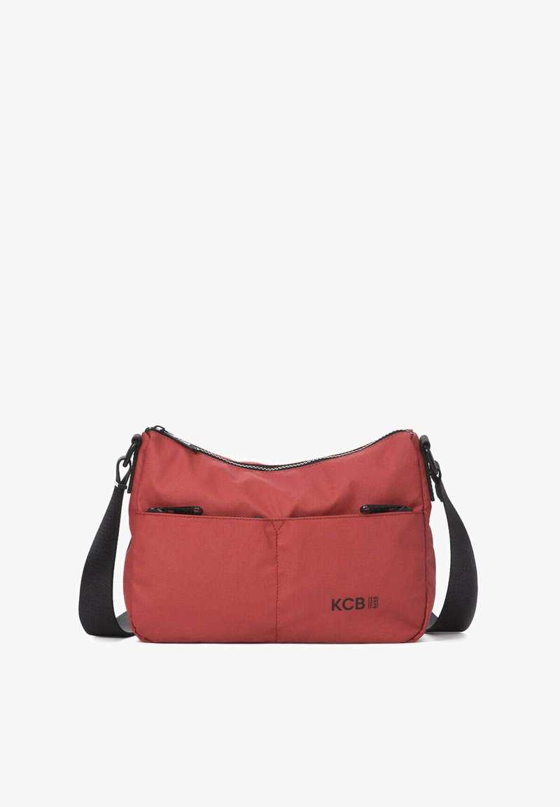 Bolso bandolera rojo de nylon con forma curva, dos bolsillos delanteros con cremallera y una correa ajustable. Presenta el logo de KCB en el lateral.
