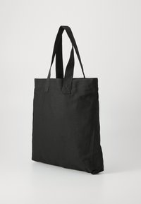 Sac en toile noir avec des poignées plates doubles et une forme rectangulaire. Texture lisse, sans embellissements ni motifs visibles.