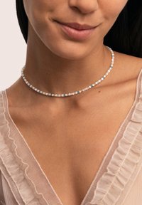 Collar choker de cuentas multicolores que presenta pequeñas cuentas redondas en tonos pastel de rosa, azul y marfil, con una textura suave.