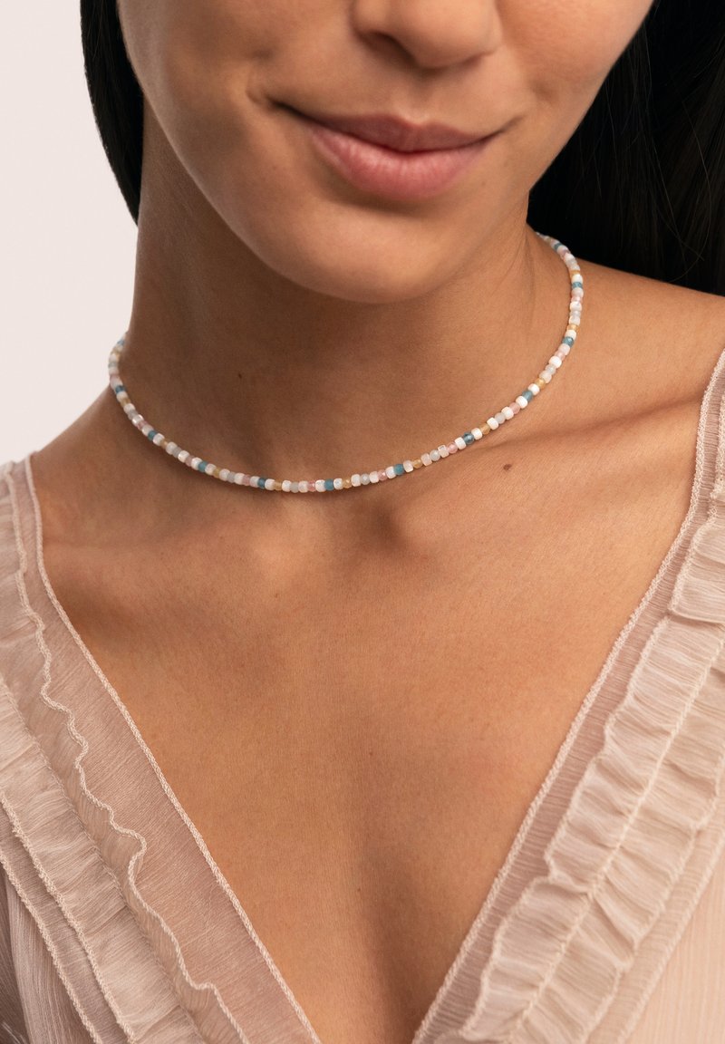 Collar choker de cuentas multicolores que presenta pequeñas cuentas redondas en tonos pastel de rosa, azul y marfil, con una textura suave.