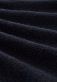 Țesătură de un albastru închis, cu o suprafață moale și texturată, având valuri delicate și cute care accentuează profunzimea și bogăția sa.