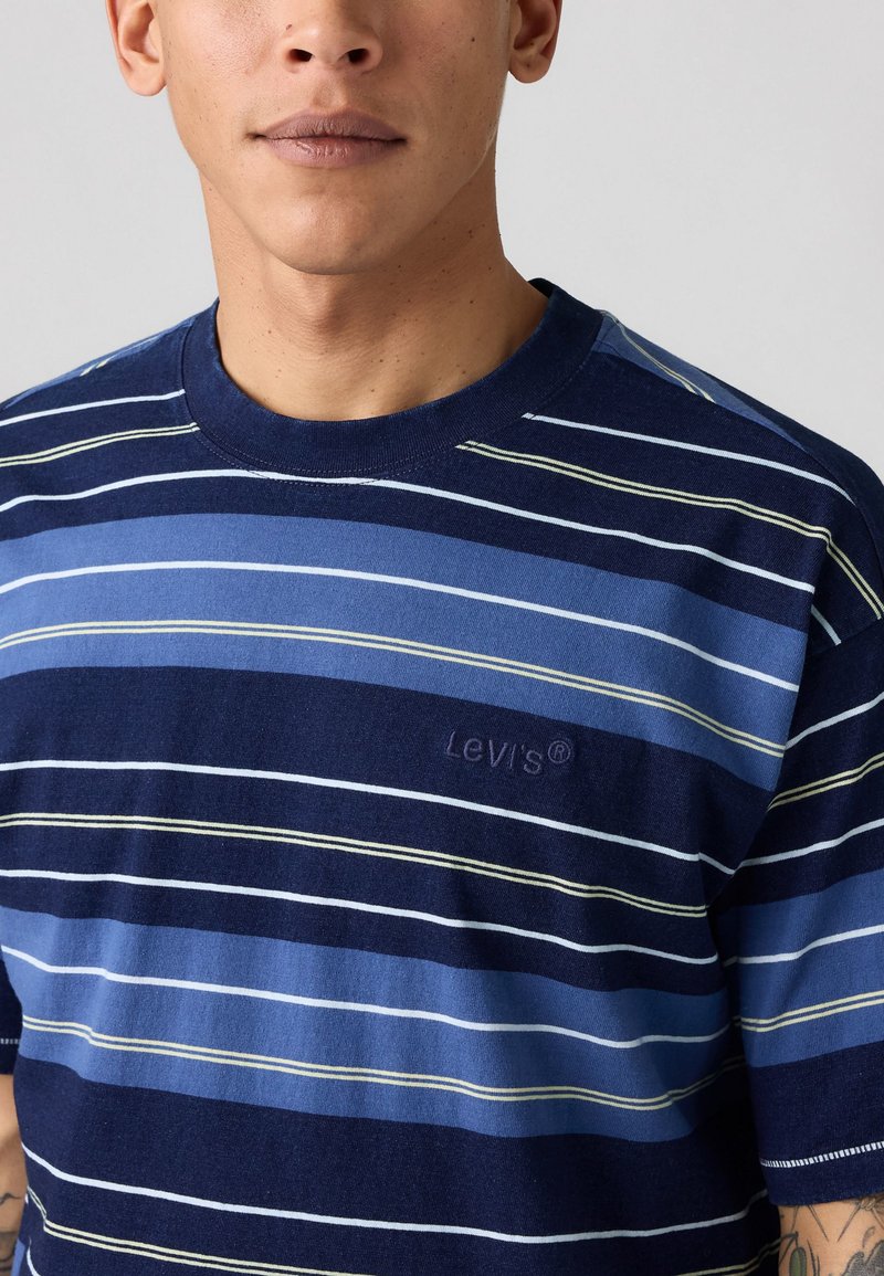 Pasiasta koszulka Levi's w kolorze niebieskim i granatowym, z poziomymi liniami w żółtych akcentach, wykonana z bawełny, z okrągłym dekoltem i haftowanym logo.