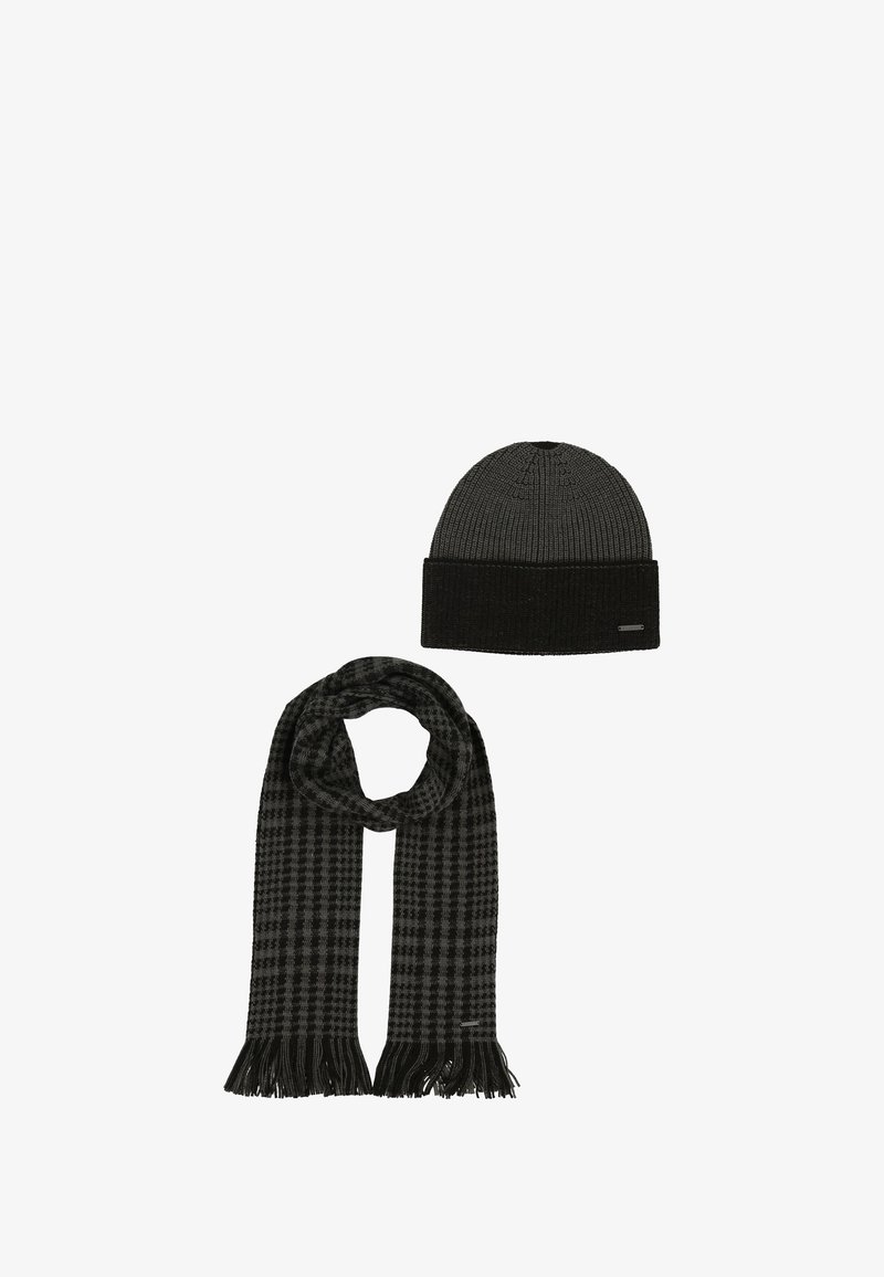 Cappello a cuffia nero in maglia a coste con orlo ripiegato e sciarpa a quadri abbinata con estremità frangiate. Entrambi gli articoli hanno una texture morbida.