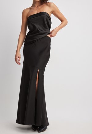 Svart strapless aftonklaff, satinmaterial, figurnära livstycke, flödande kjol med sidoflik, slät textur, ankellång, minimalistisk design.