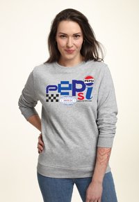 Felpa grigia in cotone, caratterizzata da un design grafico colorato con il testo e i loghi "PEPSI", che includono motivi a scacchi e un globo.